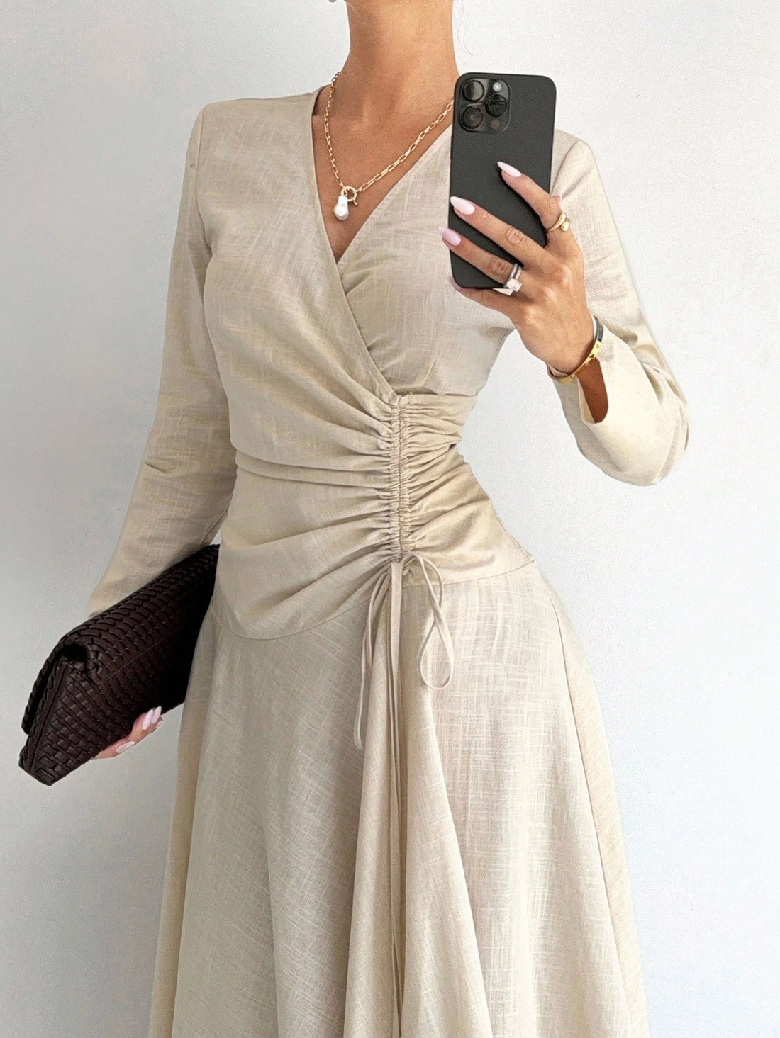 Wrap yourself in effortless sophistication with this stunning beige cotton-linen blend dress. The flattering wrap silhouette hugs your curves just right, while delicate pleating at the waist adds dimension and visual interest. An asymmetrical hem brings a modern twist to a timeless style, making it perfect for everything from brunch dates to evening outings. Breathable and comfortable, this versatile piece transitions seamlessly from season to season. Whether you're dressing up or keeping it casual, this dr