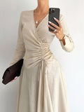 Wrap yourself in effortless sophistication with this stunning beige cotton-linen blend dress. The flattering wrap silhouette hugs your curves just right, while delicate pleating at the waist adds dimension and visual interest. An asymmetrical hem brings a modern twist to a timeless style, making it perfect for everything from brunch dates to evening outings. Breathable and comfortable, this versatile piece transitions seamlessly from season to season. Whether you're dressing up or keeping it casual, this dr
