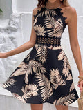 Front view of black tropical palm print halter mini dress with lace trim and crochet waist