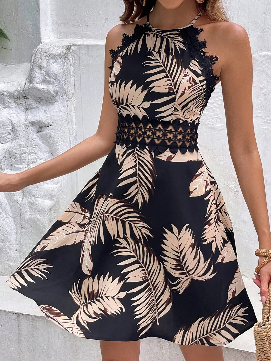 Front view of black tropical palm print halter mini dress with lace trim and crochet waist