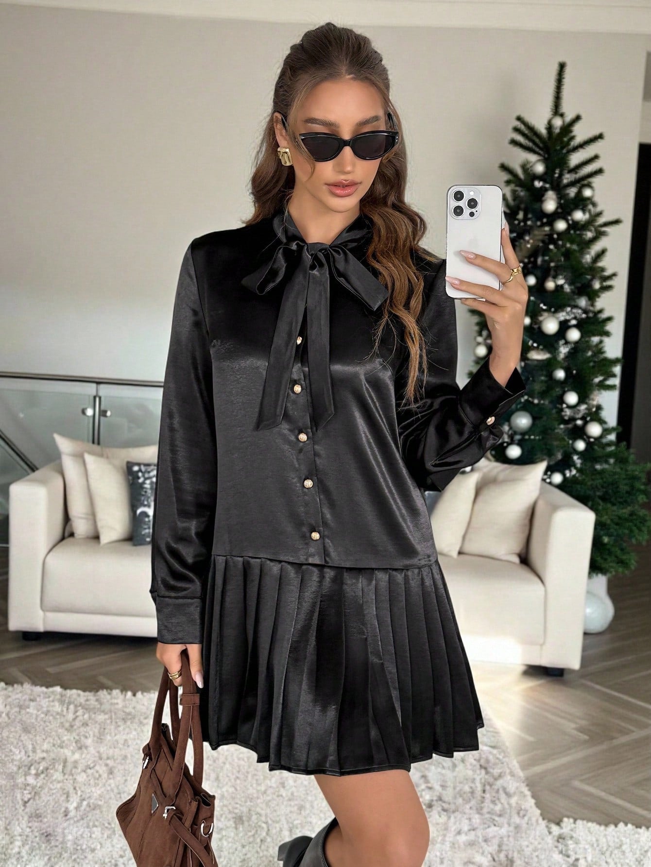 Elevate your party game with this stunning black pleated mini dress that's equal parts sophisticated and fun. The charming tie collar adds a flirty touch, while long sleeves keep things polished and put-together. Perfectly pleated throughout for a flattering silhouette that moves with you, this dress transitions seamlessly from evening events to upscale casual outings. Whether you're dancing the night away or making a chic entrance, this wardrobe essential delivers timeless elegance with a playful edge.