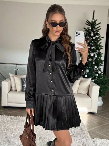 Elevate your party game with this stunning black pleated mini dress that's equal parts sophisticated and fun. The charming tie collar adds a flirty touch, while long sleeves keep things polished and put-together. Perfectly pleated throughout for a flattering silhouette that moves with you, this dress transitions seamlessly from evening events to upscale casual outings. Whether you're dancing the night away or making a chic entrance, this wardrobe essential delivers timeless elegance with a playful edge.