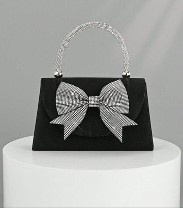 Step out in style with this Elegant Black Satin Clutch, featuring a sparkling rhinestone bowknot that adds just the right amount of glam. Perfect for parties and weddings, this luxury evening handbag is your go-to for keeping essentials close while turning heads. Its sleek design and dazzling detail make it a playful yet sophisticated accessory that brightens any outfit. Ready to dazzle? This clutch is your new best party buddy!