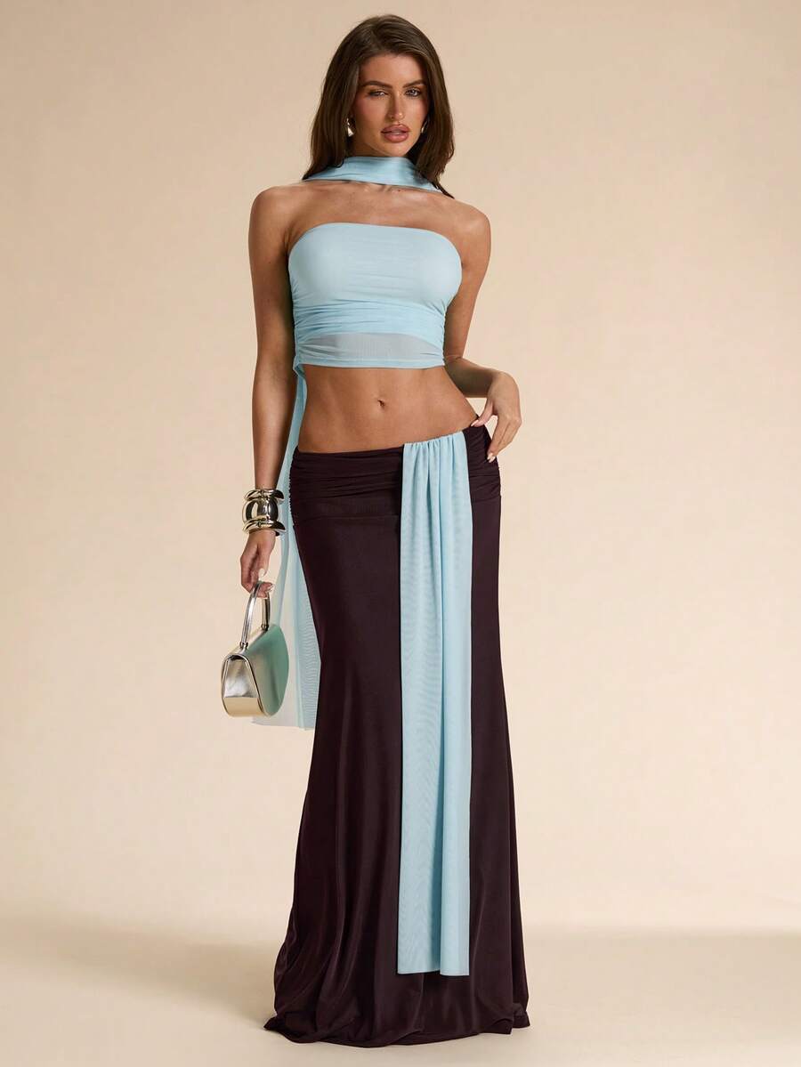 Make a statement at the beach with this elegant two-piece dress set. The asymmetric design combines a cropped top with a flowing maxi skirt in complementary blue and brown hues. The backless silhouette offers a daring, sophisticated look while remaining comfortable for all-day wear. Perfect for beach vacations, resort dinners, or tropical getaways, this set delivers effortless style and versatility for any occasion.