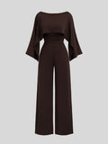 Front view of dark brown cape-sleeve wide-leg jumpsuit with a ruched high waist
