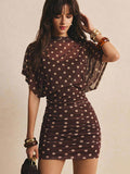 Front close view of brown polka-dot mini dress with batwing mesh overlay and ruched skirt