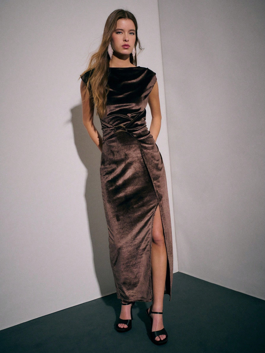 Slip into sophistication with this stunning brown velvet gown that's ready to turn heads at any autumn soirée. The luxurious velvet fabric drapes beautifully while the pleated waistband cinches your silhouette with effortless elegance. Flowy side slits add a playful touch of movement and allure, making every step feel like a red carpet moment. Perfect for formal events, evening galas, or whenever you want to feel absolutely fabulous. This dress proves that timeless style never goes out of season.