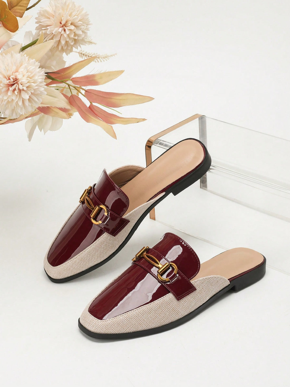Step into effortless style with these burgundy flat mules that blend sophistication with comfort. The striking square toe silhouette pairs beautifully with a charming beige linen inlay, creating a look that's both modern and timeless. Whether you're heading to the office or out for a casual weekend adventure, these versatile mules transition seamlessly from season to season. The flat sole keeps you grounded and comfy all day long, while the rich burgundy hue adds that perfect pop of color to your fall and w