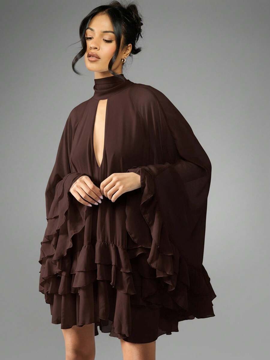 Turn heads effortlessly in this chiffon cape mini dress, designed with a playful high neck keyhole and charming tiered ruffle hem. Its light, flowing fabric adds movement and grace, perfect for making every special occasion feel unforgettable. Embrace a mix of elegance and fun with this standout piece that’s as spirited as you are.