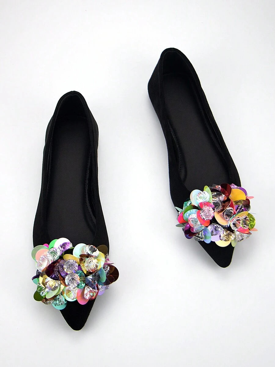 Overhead pair of black pointed-toe ballet flats with colorful iridescent jewel and sequin clusters on each vamp