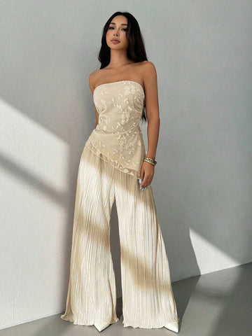Make an unforgettable impression in this Elegant Floral Embroidered Mesh Crop Top and Pants Set. Tailored for petite frames, this sophisticated all-white ensemble combines timeless elegance with modern flair. The strapless bandeau crop top features exquisite floral embroidery with asymmetrical lace-up detailing and charming puff sleeves. Paired with high-waisted slim-fit long pants, this set creates a refined, coordinated silhouette perfect for weddings and celebrations. 