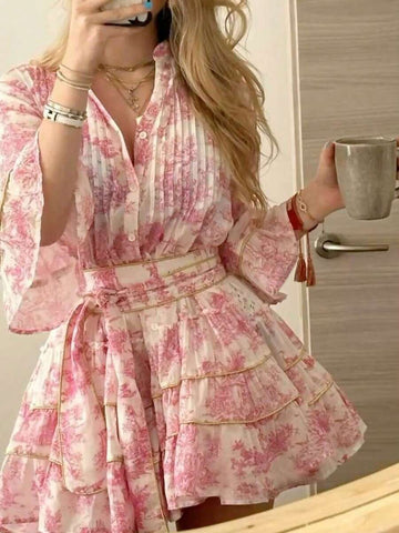 Embrace effortless elegance with this charming floral print button-front dress, designed for romantic getaways and casual adventures. The notched neckline and three-quarter flare sleeves create a flattering silhouette, while the high-waisted A-line cut offers comfortable all-day wear. Layered ruffle hem and knot details add playful boho flair. Crafted from soft woven polyester-elastane blend in a lovely pink hue, this dress transitions seamlessly from beachside strolls to evening dinners. 
