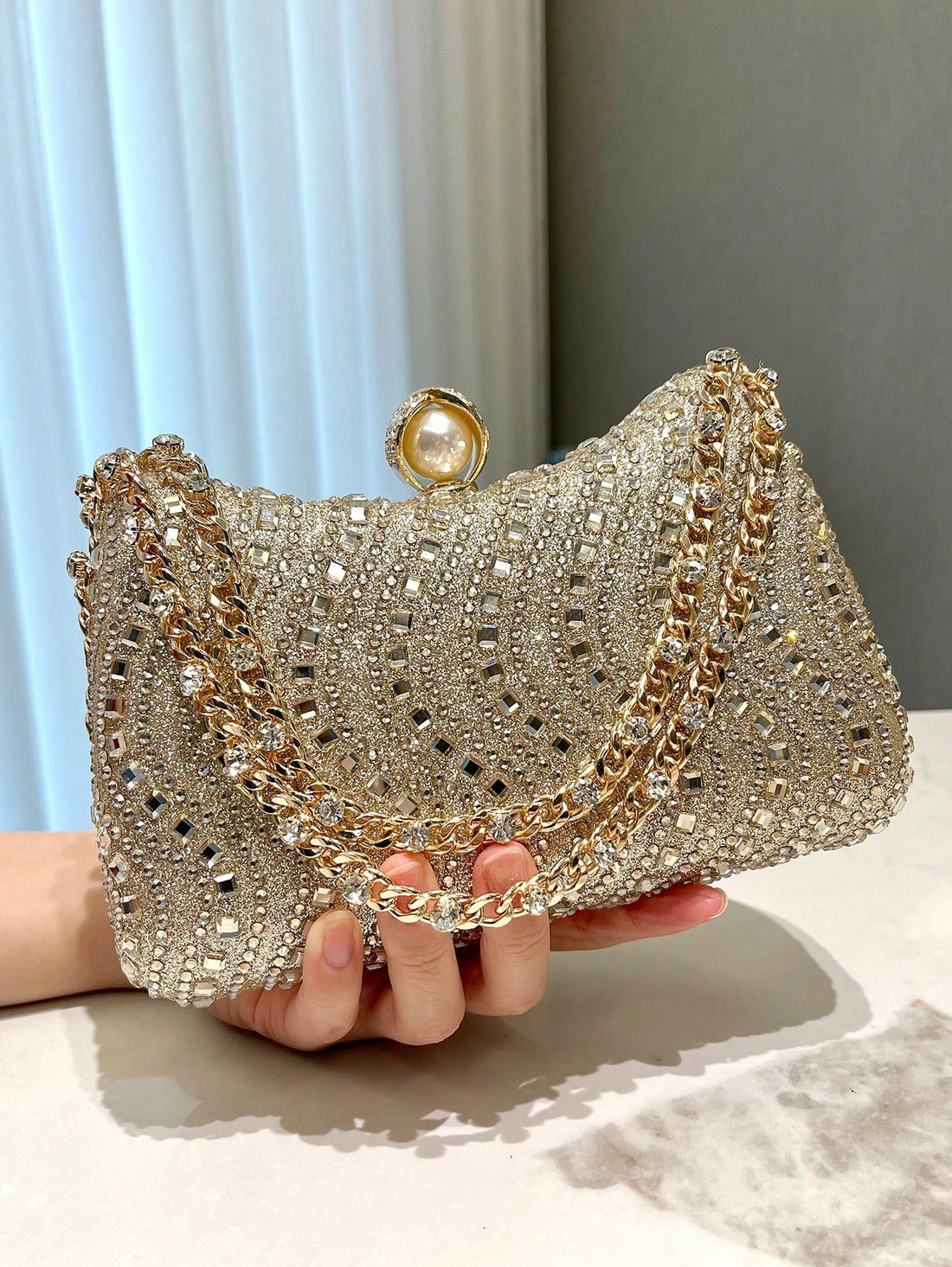 Make a statement at any event with our Elegant Gold Foil Stamped Clutch Bag. The stunning rhinestone accents add a touch of glamour, making it perfect for parties, weddings, and formal occasions. Expertly crafted with attention to detail, this clutch bag is sure to elevate any outfit.
