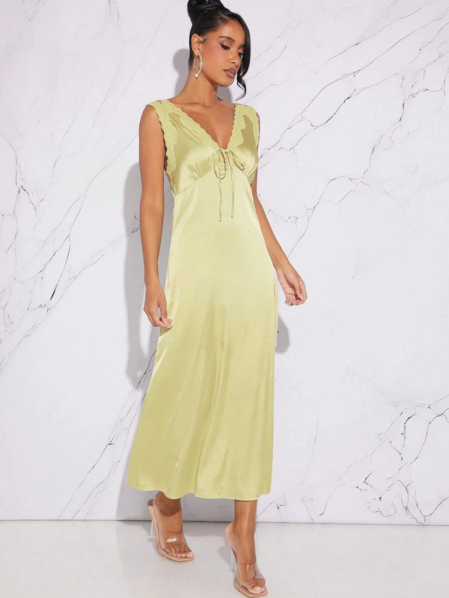 Drape yourself in charm with this satin dress featuring a daring plunging neckline and delicate lace trim. Sleeveless and sleek, it’s perfect for turning heads at any stylish event. Let your confidence shine and dance the night away in this effortlessly stunning piece.