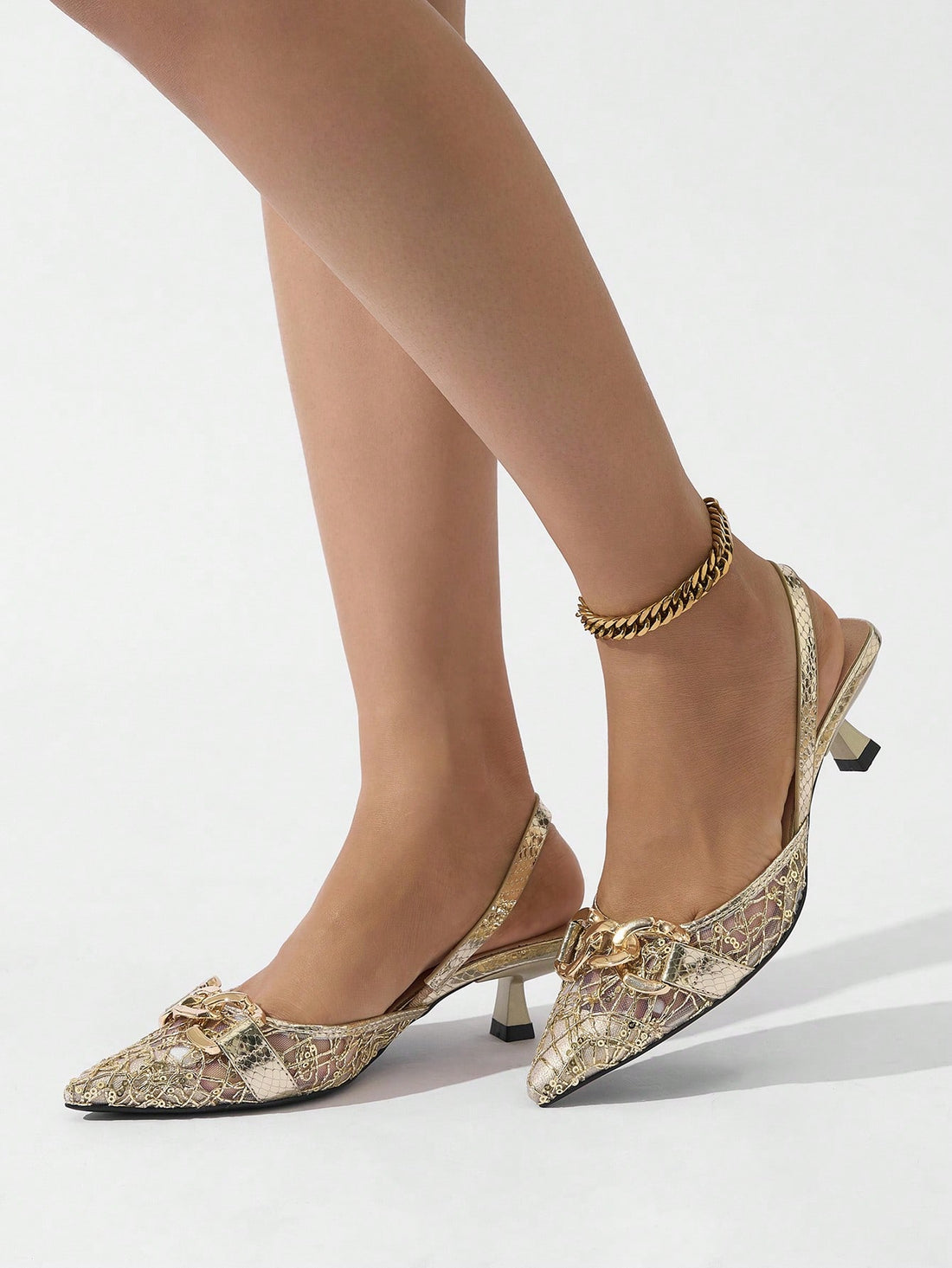 Add a touch of elegance and playfulness to your spring/summer events with these Metallic Gold Pointed Toe High Heel Pumps. The chain strap and lace patchwork adds a unique and trendy touch to these pumps. Perfect for standing out and making a statement!