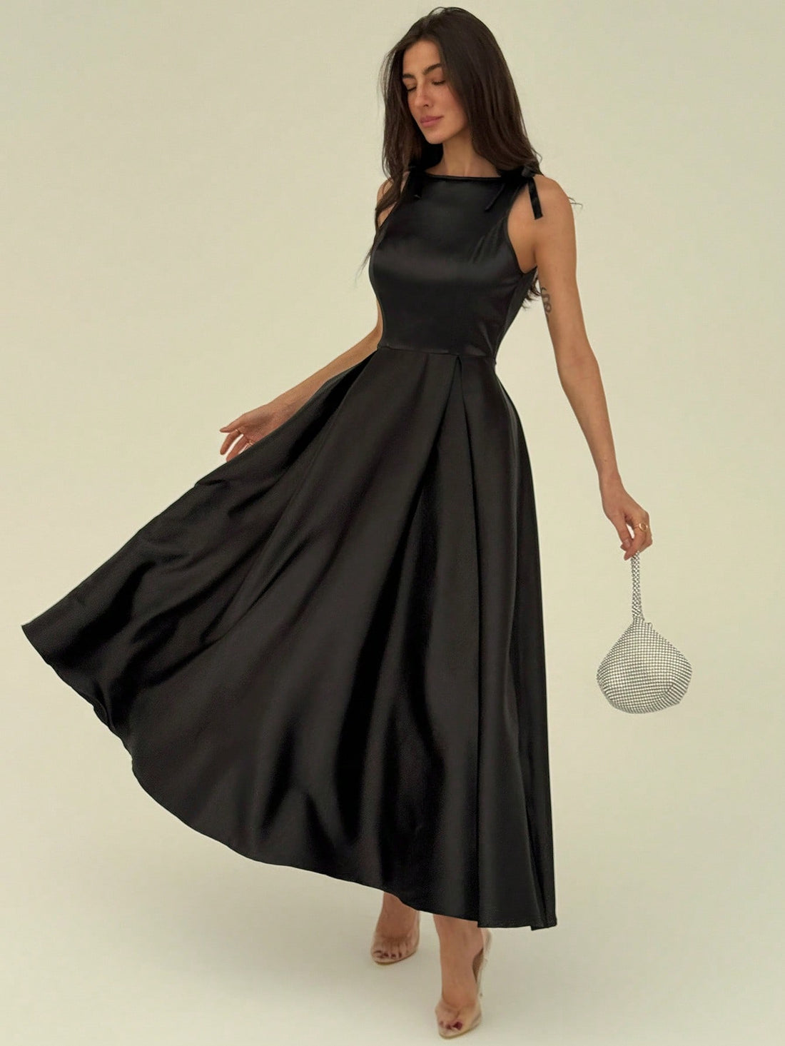 This sleek black satin dress pairs minimalist charm with a flirty bow detail, making it ideal for modern parties. Its smooth fabric catches the light, while the subtle design keeps you effortlessly chic. Slip into this dress to turn heads and keep the vibe fun and fresh all night long.