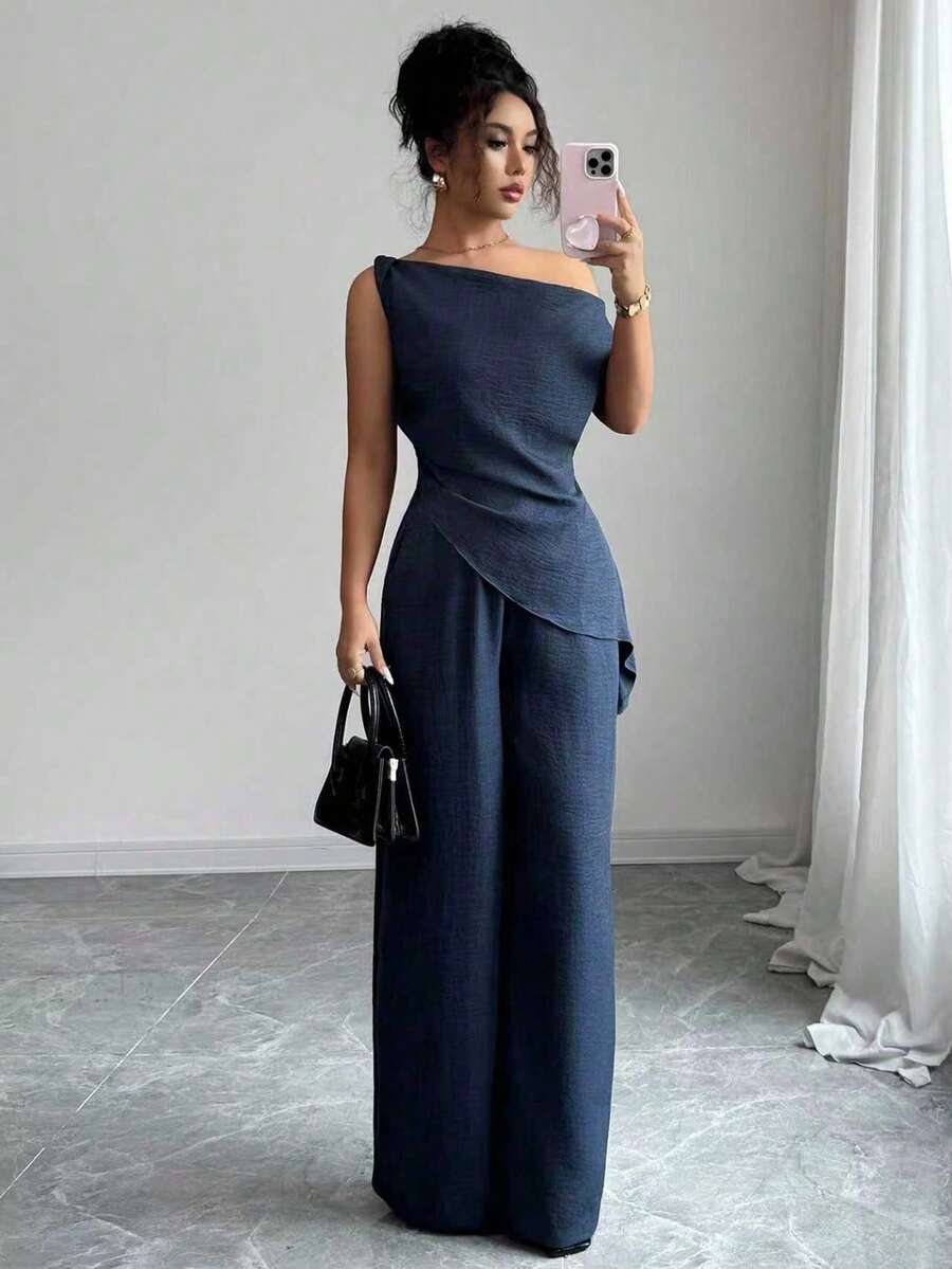 Sophisticated two-piece set designed for tall women who value understated elegance. The navy blue pleated blouse features clean lines and refined tailoring, paired with matching high-waisted pants that elongate the silhouette

