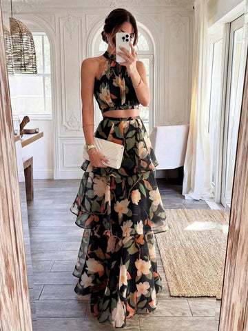 Front view of black botanical halter crop top and tiered maxi skirt set