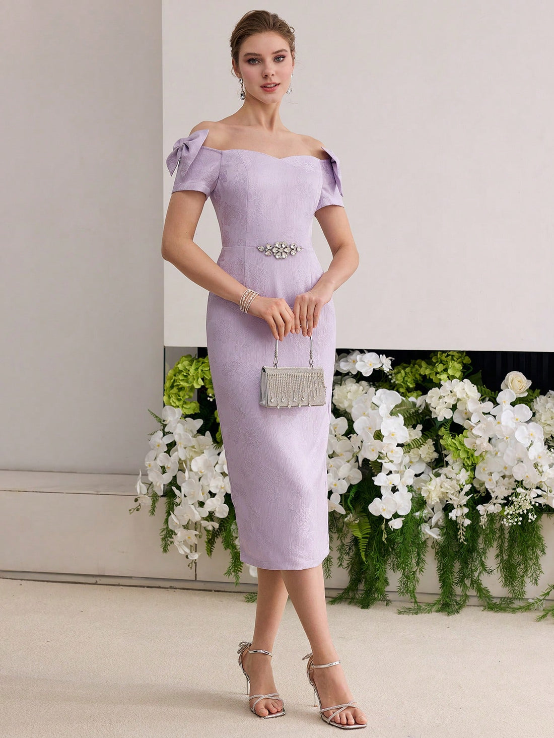 Step into the spotlight with this playful off-shoulder dress featuring a delicate floral jacquard pattern that adds texture and charm. The flirtatious bow accentuates your waist, while subtle rhinestone details bring just the right amount of sparkle for any occasion. Designed to turn heads and keep your style fun and elegant, this dress is perfect for making memorable moments even more delightful.