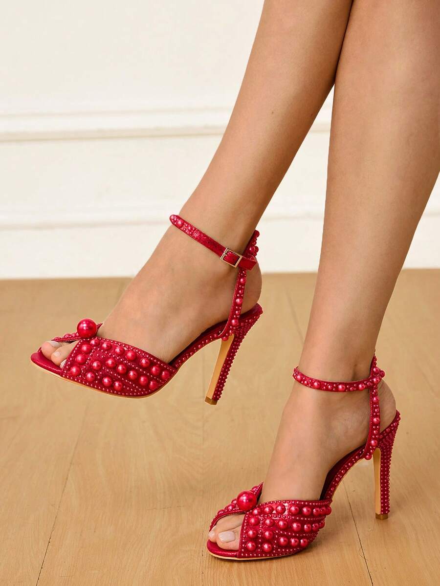 Step into sophistication with these stunning pearl-adorned peep-toe stiletto sandals! Designed for the woman who refuses to compromise on glamour, these beauties feature delicate pearl embellishments that catch the light beautifully. The peep-toe silhouette offers a flirty peek while the sleek stiletto heel elongates your legs and elevates any ensemble. Whether you're walking down the aisle, dancing at a soirée, or turning heads at your next special event, these sandals deliver that perfect blend of eleganc