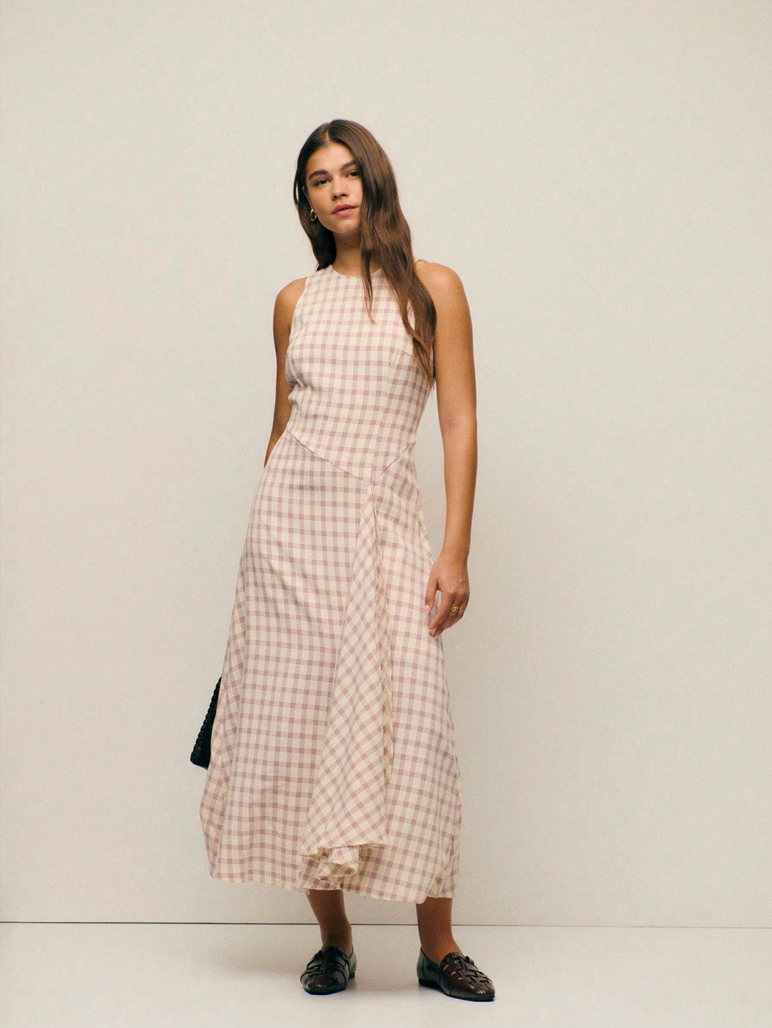 Step into effortless sophistication with this charming pink checked midi dress. The sleek sleeveless silhouette and high round neckline create a timeless, polished look that transitions seamlessly from brunch to evening plans. The classic gingham pattern adds a touch of vintage-inspired whimsy, while the midi length offers graceful coverage and flattering proportions. Perfect for anyone who loves a dress that's both put-together and playfully chic—pair it with your favorite sneakers for casual vibes or dres