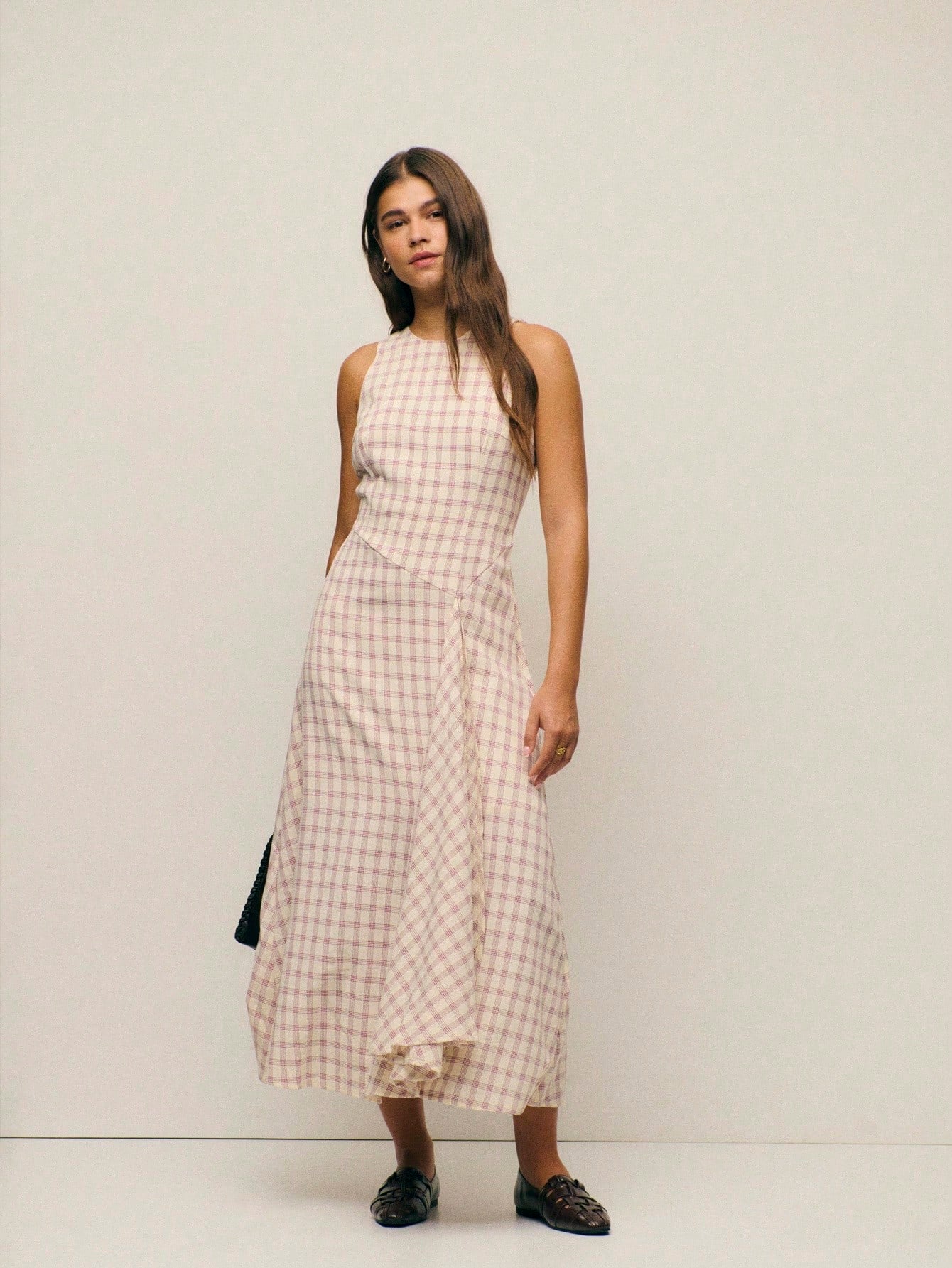 Step into effortless sophistication with this charming pink checked midi dress. The sleek sleeveless silhouette and high round neckline create a timeless, polished look that transitions seamlessly from brunch to evening plans. The classic gingham pattern adds a touch of vintage-inspired whimsy, while the midi length offers graceful coverage and flattering proportions. Perfect for anyone who loves a dress that's both put-together and playfully chic—pair it with your favorite sneakers for casual vibes or dres