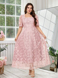 A woman models a light pink lace midi dress with puff sleeves, a square neckline, and a flared skirt in a bright room with a large mirror and window.