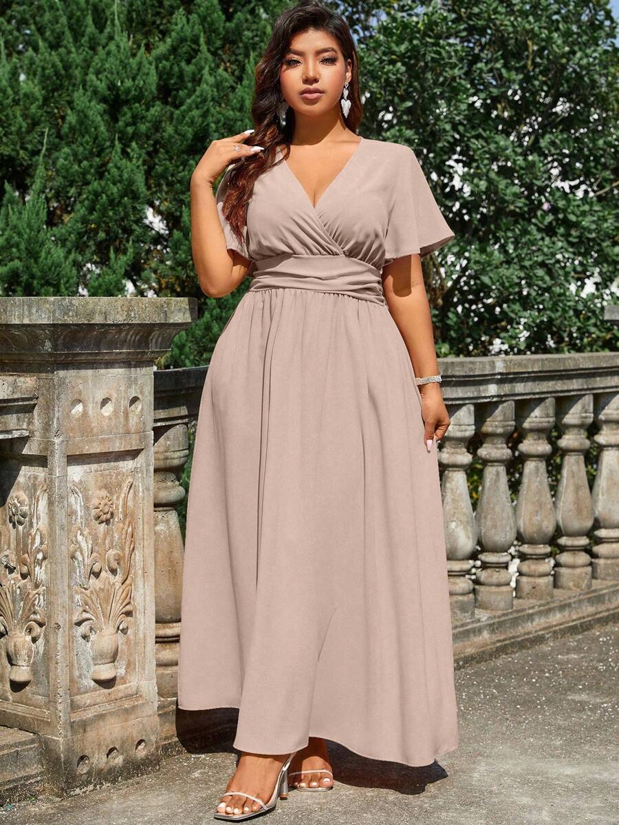 Elevate your summer wedding wardrobe with this sophisticated plus-size maxi dress. The flattering V-neckline and cross-wrap design create a graceful silhouette, while short sleeves offer modest coverage. Crafted for comfort and style, this dress transitions seamlessly from ceremony to reception. Perfect for special occasions, it combines timeless elegance with contemporary design. Available in sizes designed to fit and flatter every body type.