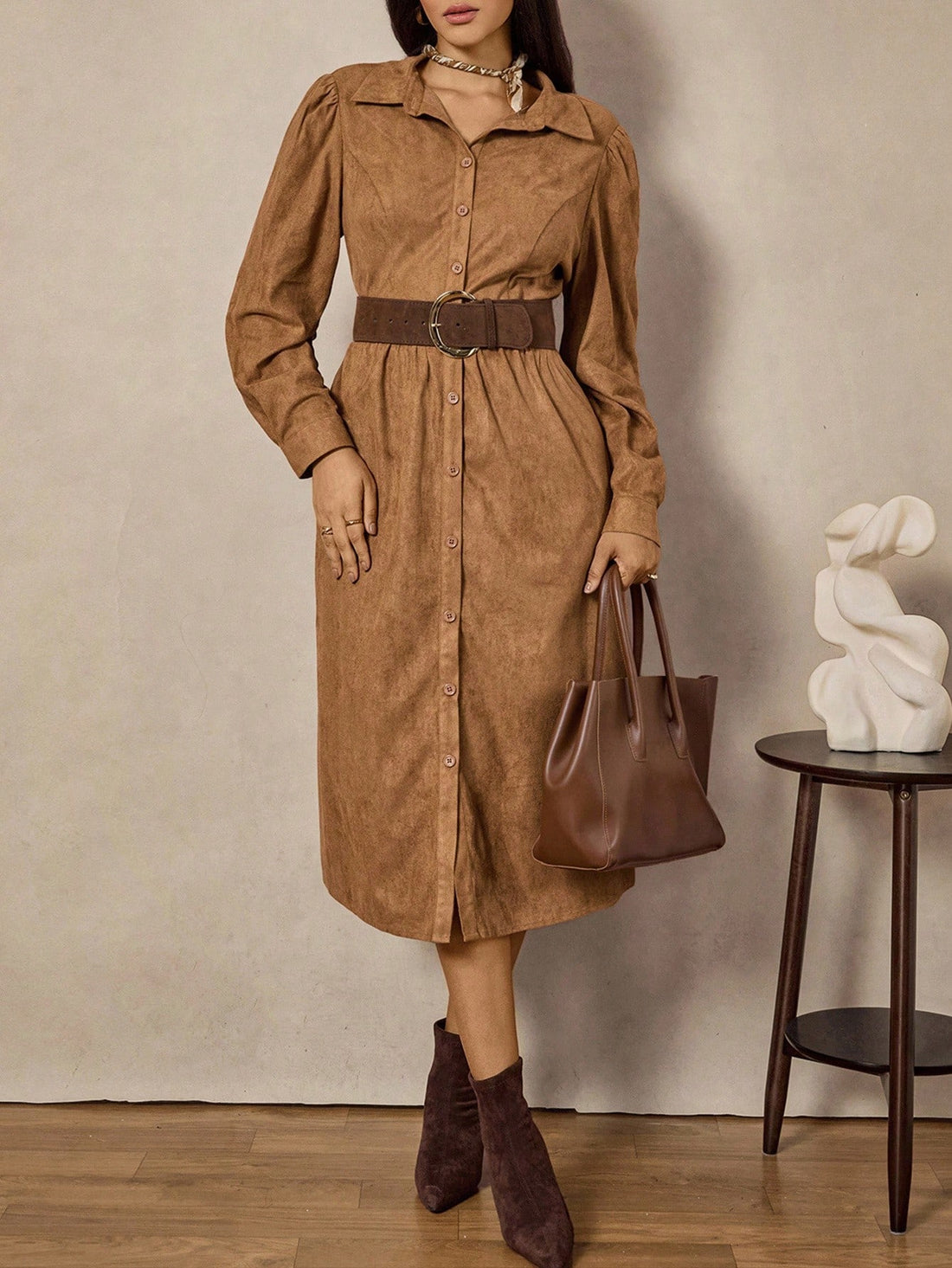 Step into autumn with a playful twist wearing this elegant plus size shirt dress. Crafted from soft brown suede, it features a charming vintage coin pattern that adds a touch of whimsy to your wardrobe. The long sleeves keep you cozy as the temperatures dip, while the flattering cut embraces your curves with confidence. Perfect for layering or wearing solo, this dress brings vintage charm and autumn warmth together in one stylish package.