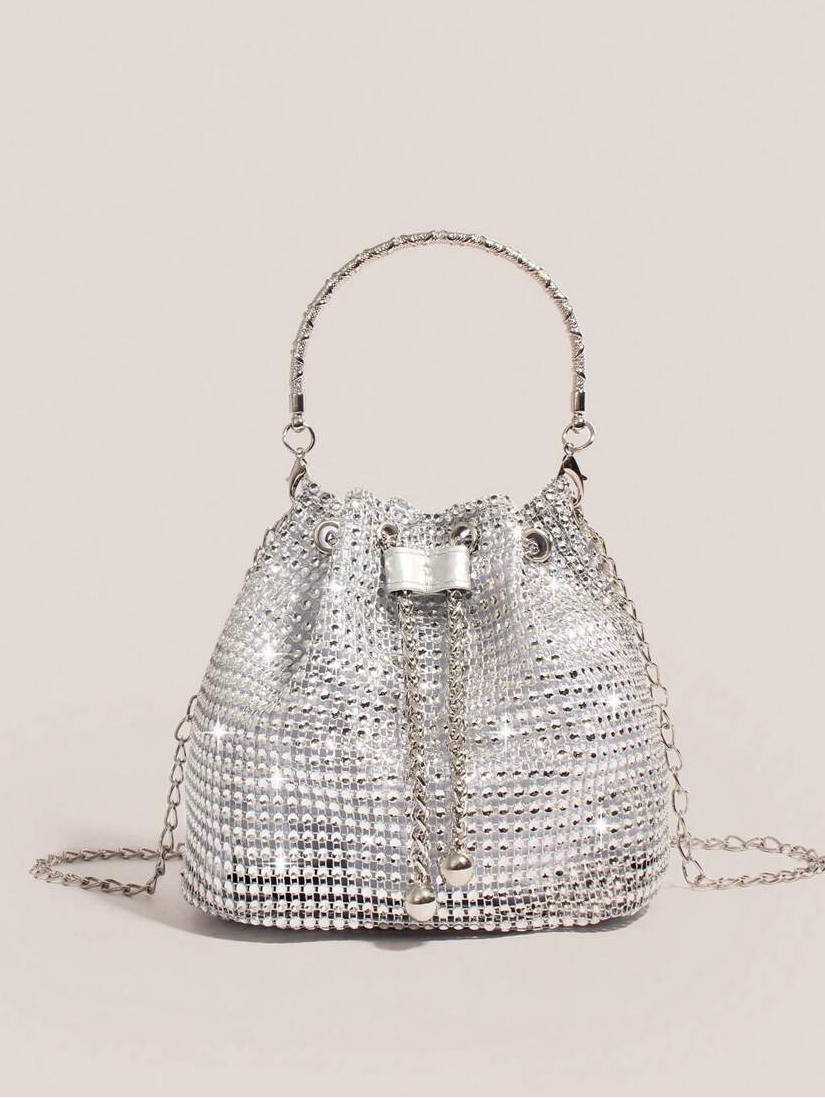 Elevate your everyday carry with this stunning gold bucket tote that's equal parts glamorous and practical. Adorned with shimmering rhinestone embellishments, it catches the light beautifully whether you're heading to the office, jetting off on an adventure, or making an entrance at your next event. The spacious bucket silhouette keeps your essentials organized while the polished gold finish adds that touch of sophistication you've been craving. Versatile enough to transition from day to night, this tote is