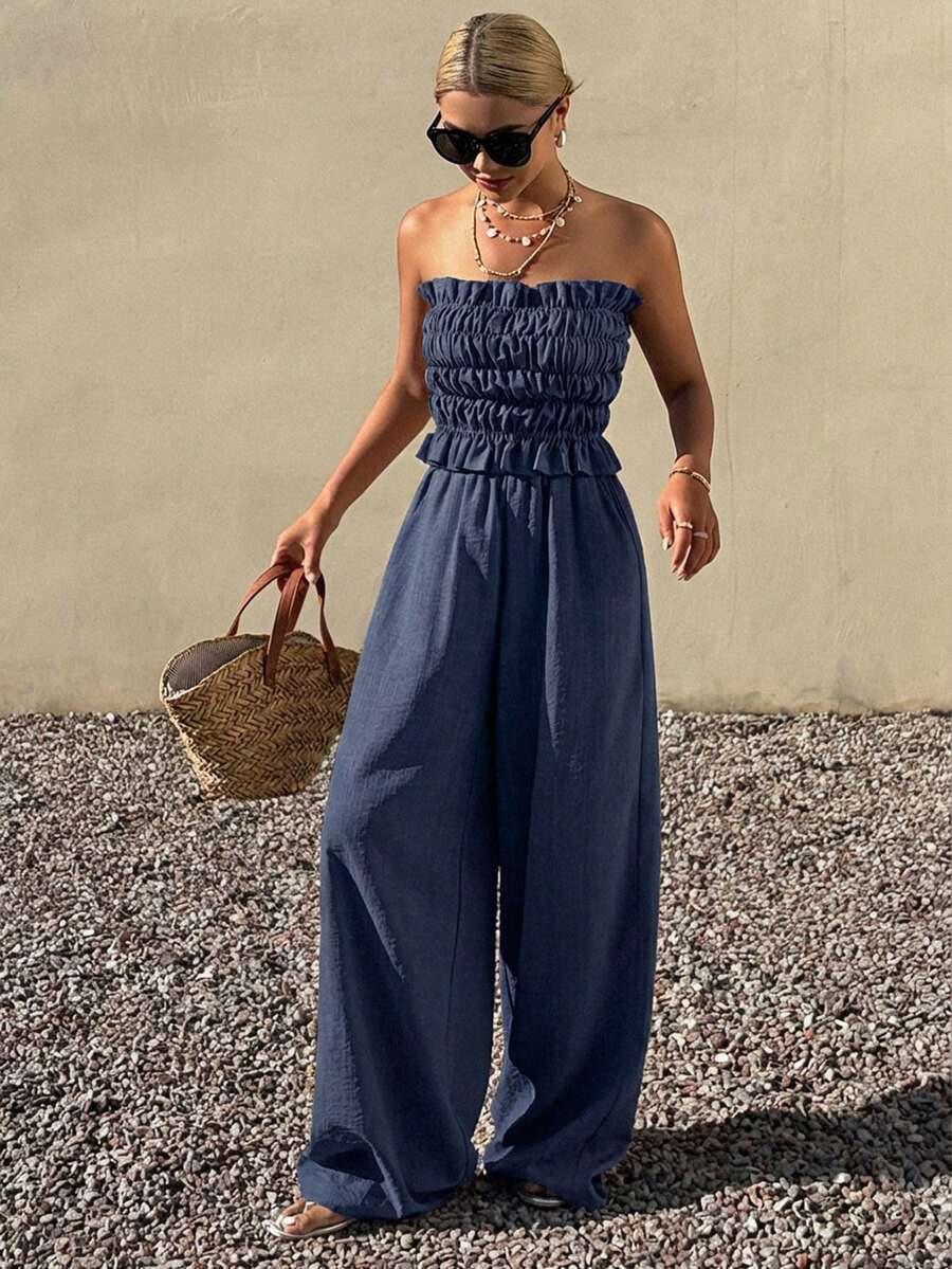 Elevate your spring and summer wardrobe with this sophisticated two-piece set. The strapless bandeau top features elegant ruffle detailing and an asymmetrical cut, while the straight-leg pants offer a polished silhouette. Crafted from 100% polyester with slight stretch for comfort, this versatile ensemble transitions seamlessly from office meetings to beach getaways. The navy blue colorway pairs effortlessly with accessories. Machine washable for easy care.