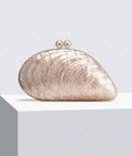 Add a touch of seaside charm to your formal look with this elegant shell-inspired handbag. Adorned with delicate pearl accents, it effortlessly blends sophistication with a playful nod to the ocean. Perfect for special occasions, it’s the accessory that makes your outfit shimmer with personality and grace.