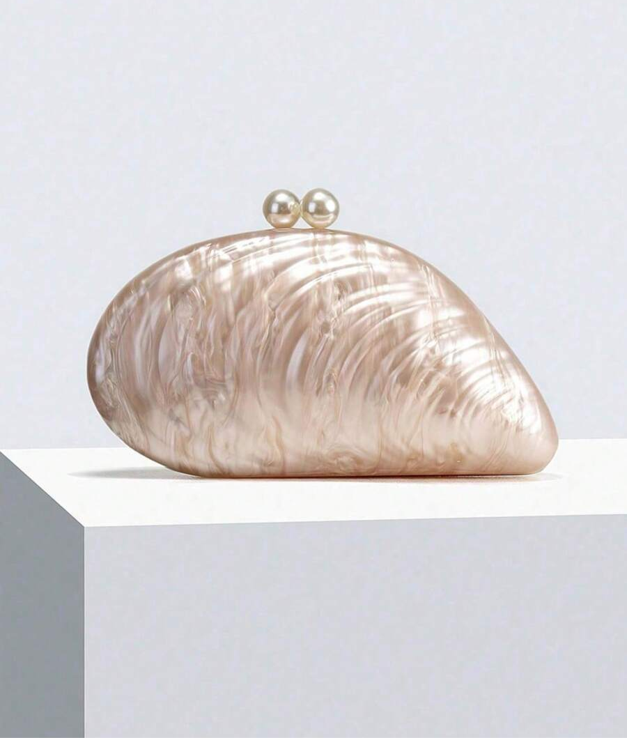 Add a touch of seaside charm to your formal look with this elegant shell-inspired handbag. Adorned with delicate pearl accents, it effortlessly blends sophistication with a playful nod to the ocean. Perfect for special occasions, it’s the accessory that makes your outfit shimmer with personality and grace.