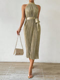 This elegant dress features a pleated waist and a halter neck, complemented by a solid color design. With a stylish waist belt, this versatile dress is perfect for any occasion. Look and feel confident no matter where you wear it.
