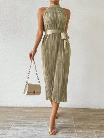 This elegant dress features a pleated waist and a halter neck, complemented by a solid color design. With a stylish waist belt, this versatile dress is perfect for any occasion. Look and feel confident no matter where you wear it.
