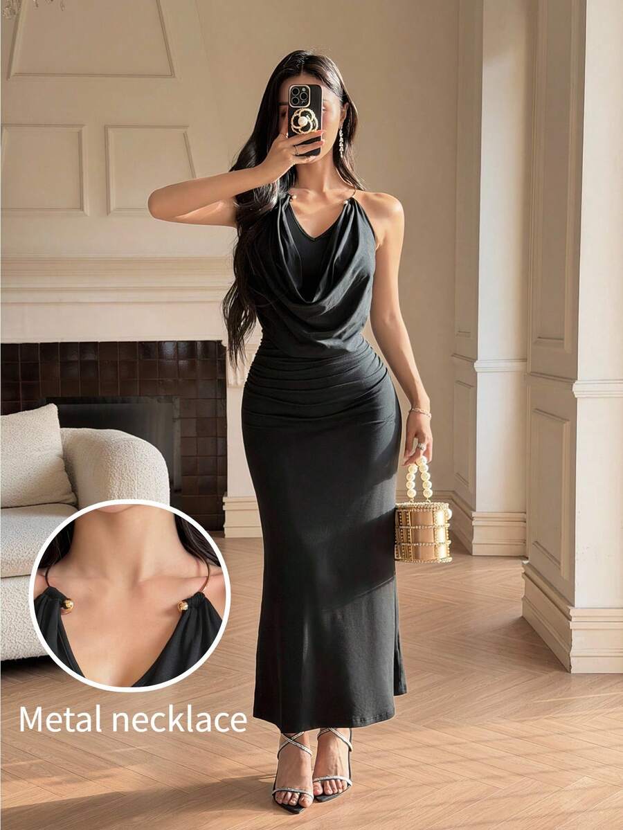 Front full-length view of black cowl-neck halter maxi dress with ruched waist