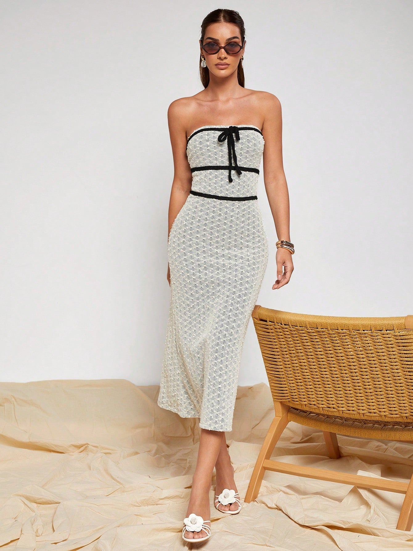 Slip into effortless sophistication with this stunning strapless midi dress that's equal parts chic and fun. Crafted from soft, breathable knitted fabric, it hugs your curves in all the right ways while the elegant black trim adds a touch of drama. The charming tie-front detail lets you customize your look—cinch it tight for a defined silhouette or keep it loose and breezy. Perfect for date nights, garden parties, or whenever you want to feel absolutely fabulous without trying too hard.