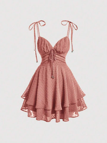 Elevate your wardrobe with this charming Swiss Dot Tie Shoulder Cami Dress. Featuring delicate spaghetti straps, a flattering ruched bust, and a distinctive two-layer tiered hem, this piece effortlessly transitions from casual outings to special occasions. The high-waist silhouette and knot detail at the shoulders add sophisticated touches, while the short length keeps things breezy and modern. Crafted from 100% polyester woven fabric in a rich redwood tone, it's perfect for graduation season