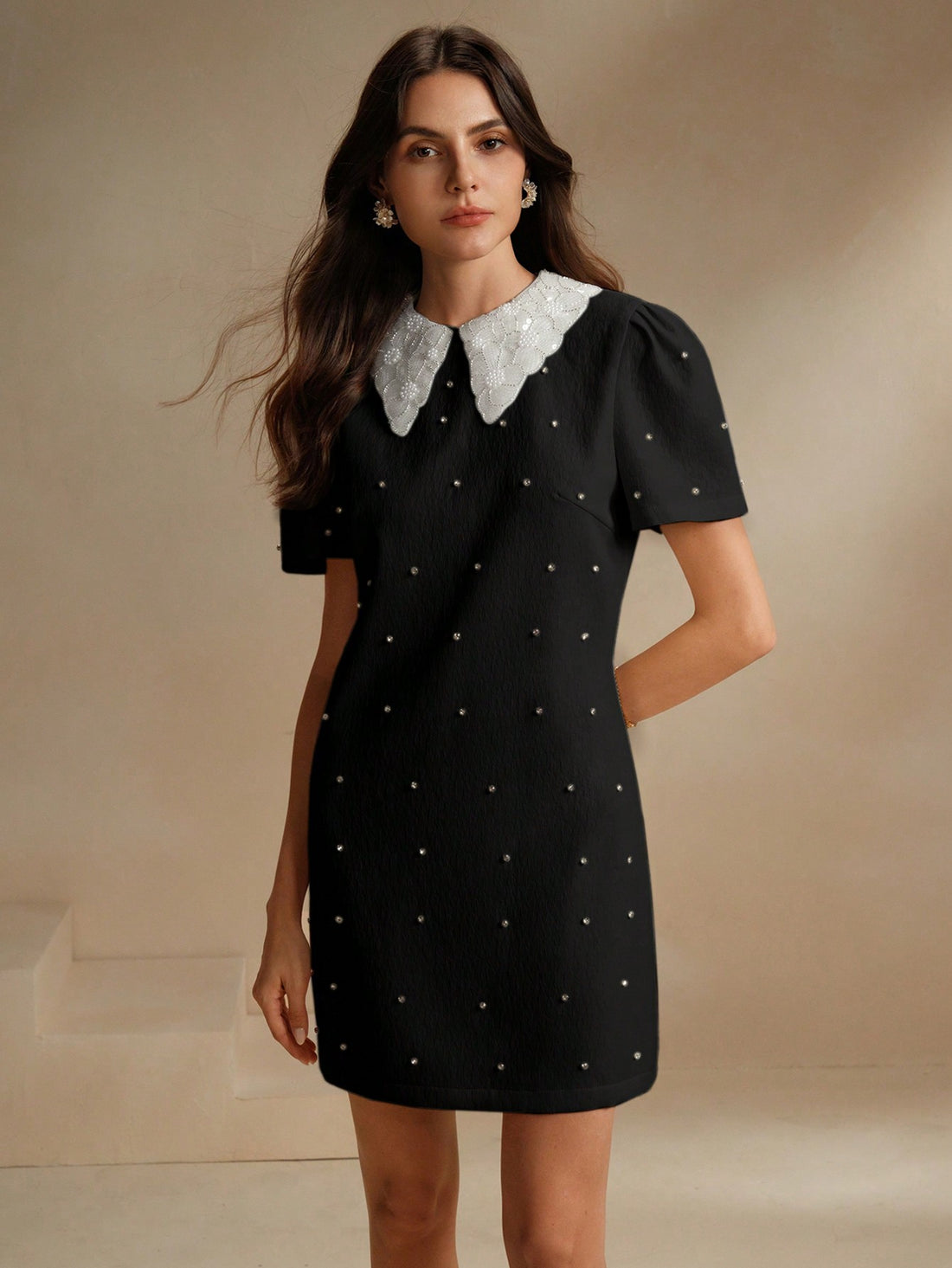 This mini dress is a nod to vintage style with its elegant design, pointy collar, and stunning crystal embellishments. Bring a touch of glamour to any occasion with this unique and playful piece. Perfect for those who love to stand out and make a statement with their fashion choices.