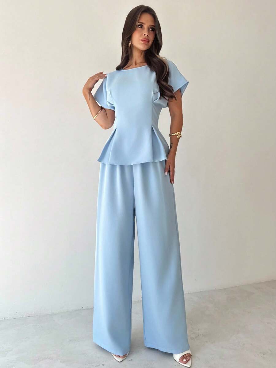 Elevate your professional wardrobe with this sophisticated 2-piece office set, designed for the modern woman who values both style and comfort. The ensemble features a graceful pleated blouse with batwing sleeves and a round neckline, paired with elegant wide-leg pants that create a flattering silhouette. Crafted from a premium blend of 94% polyester and 6% elastane, this set offers durability and subtle stretch for all-day wearability. 