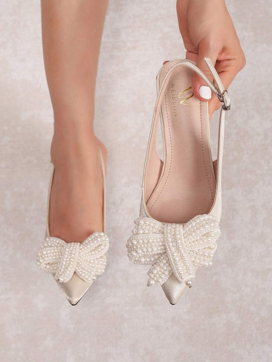 Ivory pearl bow slingback pump worn on foot with pointed toe