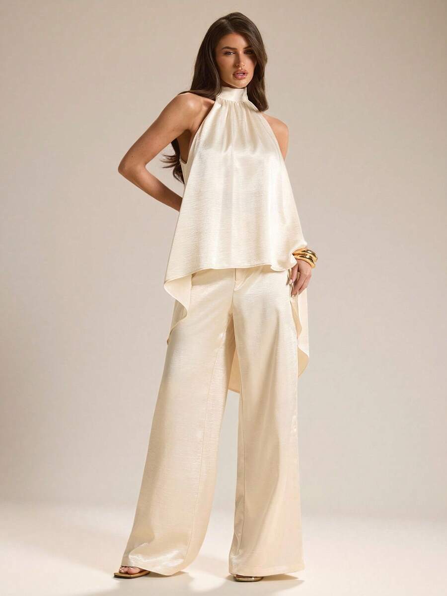 Elevate your warm-weather wardrobe with this sophisticated two-piece set. The halter neck camisole features luxurious white satin that drapes beautifully, while the coordinating pants offer a sleek, tailored silhouette. Perfect for spring and summer occasions—from casual brunches to evening gatherings. The satin finish catches light elegantly, making this set an effortless choice for anyone seeking polished, versatile style. Mix and match with your favorite accessories for endless outfit possibilities.