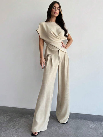 Elevate your office wardrobe with this sophisticated two-piece set. The wrap blouse features elegant ruching and an asymmetrical design with flattering batwing sleeves, while the wide-leg pants create a polished silhouette. Crafted from 100% polyester woven fabric in a luxurious apricot tone, this oversized-fit ensemble transitions seamlessly from the boardroom to evening occasions. The round neckline and structured drape make it perfect for professional settings.