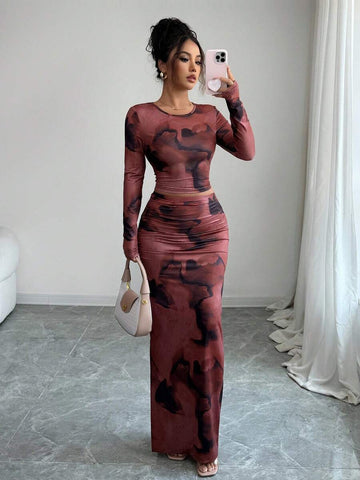Elevate your wardrobe with this stunning tie-dye ensemble featuring a cropped long-sleeve top and flowing maxi skirt. The asymmetrical design showcases vibrant multicolor patterns with ruched detailing and a flattering round neckline. Crafted from a breathable polyester-elastane blend with medium stretch, this slim-fit set offers comfort and style for spring and fall occasions. Perfect for beach outings, festivals, or casual everyday wear. Machine washable for easy care.