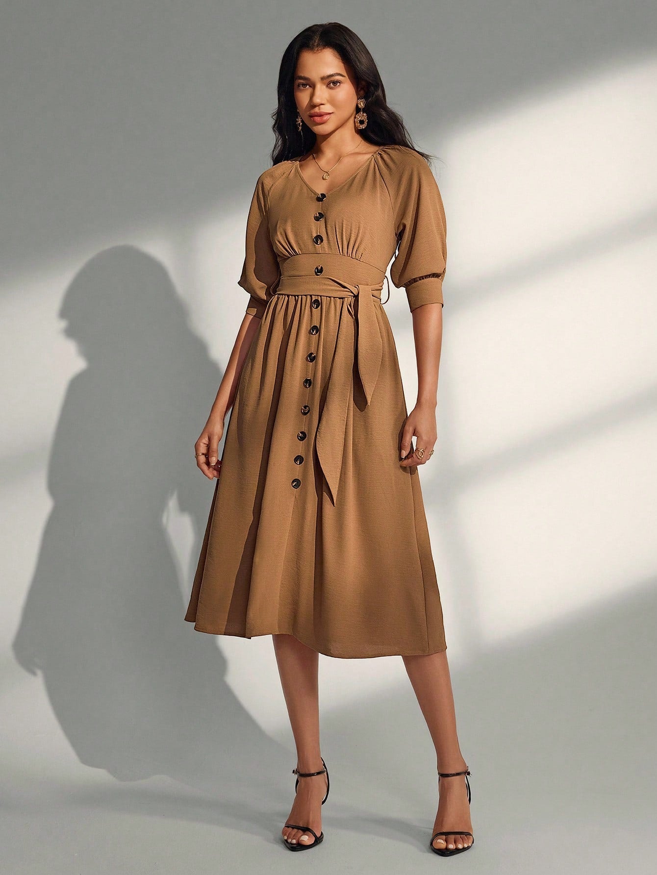 Elevate your everyday style with this charming V-neck dress that strikes the perfect balance between sophistication and fun. The flattering mid-length silhouette pairs beautifully with decorative button details and an adjustable tie waist that lets you customize your fit. Whether you're heading to brunch, a casual date, or a weekend getaway, this versatile piece transitions seamlessly from day to night. Crafted for comfort and confidence, it's the dress you'll reach for again and again.