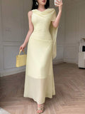 Front view of pale yellow asymmetrical draped chiffon maxi dress showing visible color, trim, and silhouette