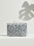 Blue white and gray woven fabric tie dye clutch bag with wristlet strap and side tassels on white textured background