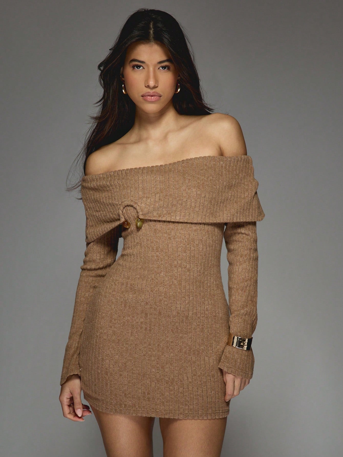 Get ready to turn heads in this Fashionable Metal Detail Rib Knit Off-Shoulder Bodycon Mini Dress! With its stylish metal detailing and off-shoulder design, this dress is sure to make a statement. The rib knit fabric hugs your curves while the long sleeves provide coverage. Perfect for a night out or special occasion.