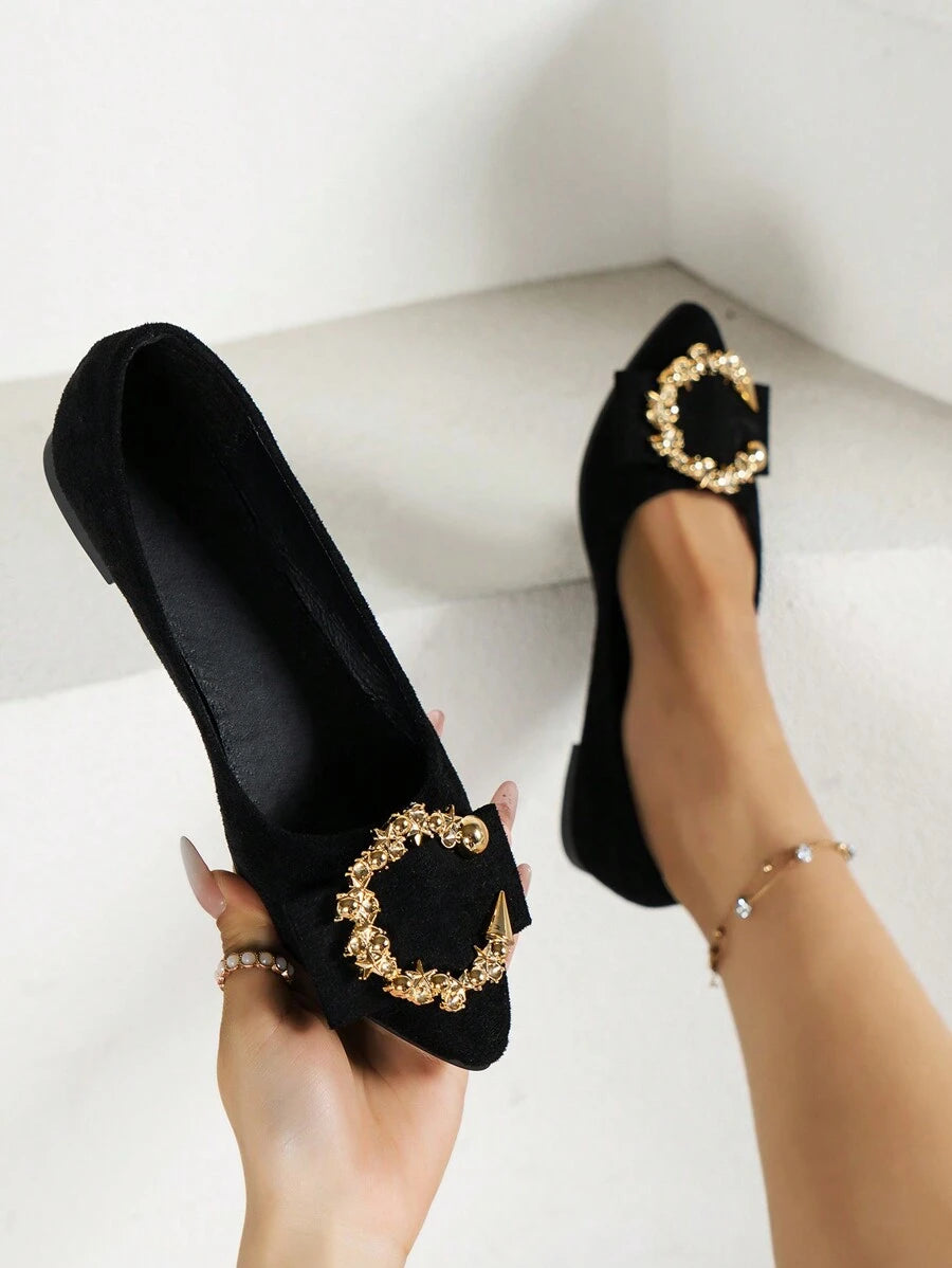 Handheld close-up and on-foot view of black pointed-toe flats with gold jeweled vamp ornament
