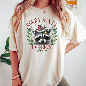 This Feral Raccoon Graphic T-Shirt is perfect for anyone looking to embrace their wild side. With a playful design featuring Santa Paws, this shirt is sure to make a statement. Made with high-quality materials, it's both comfortable and stylish. Embrace your inner raccoon and stand out from the crowd with this unique t-shirt.